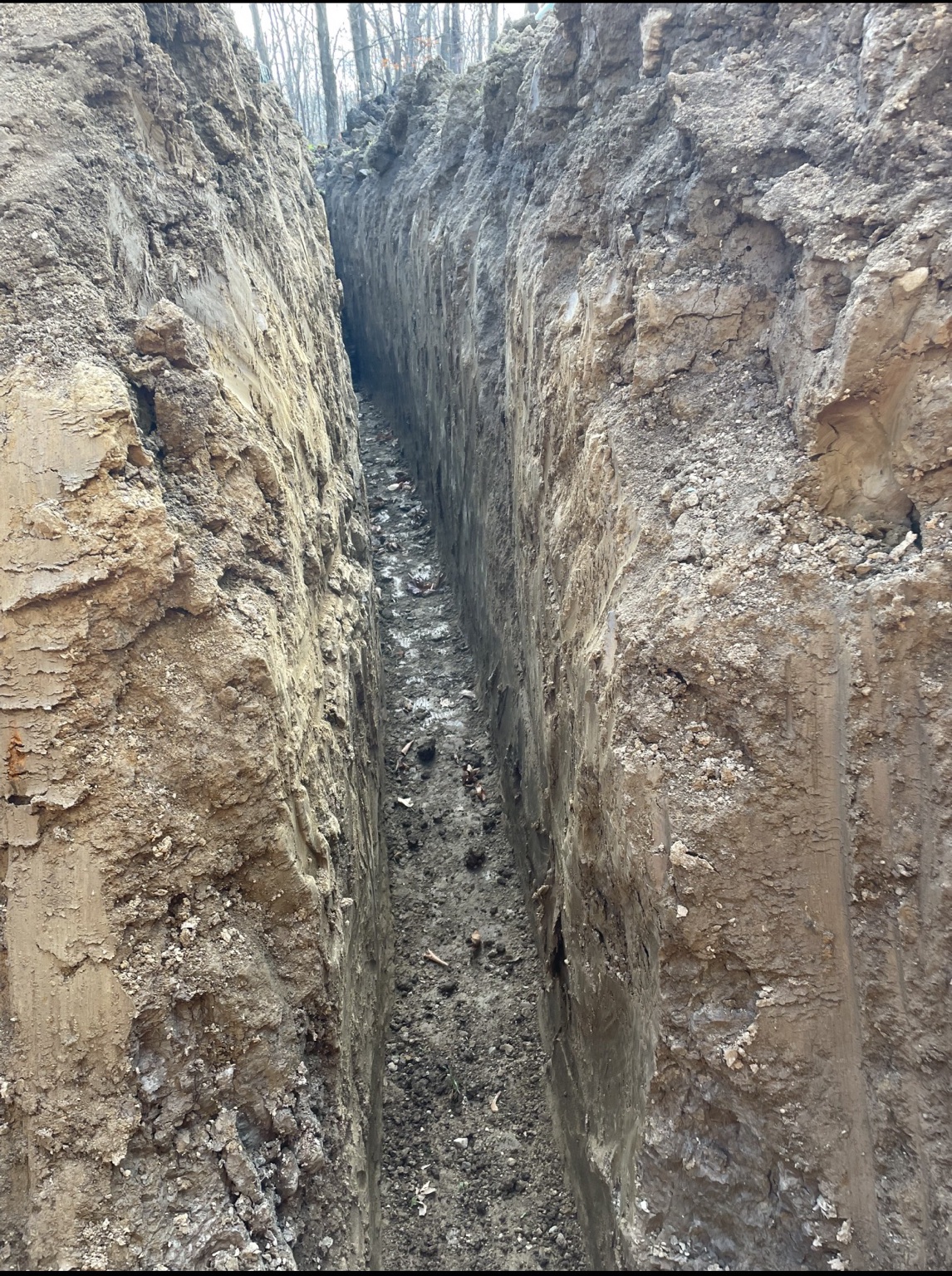 Excavated trench prepared around a home foundation